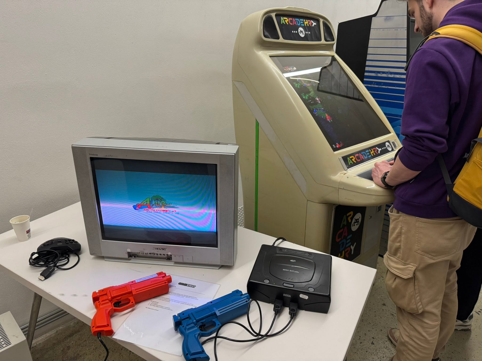 Herní stanice se Sega Saturn, světelnými pistolemi a arkádovým automatem.