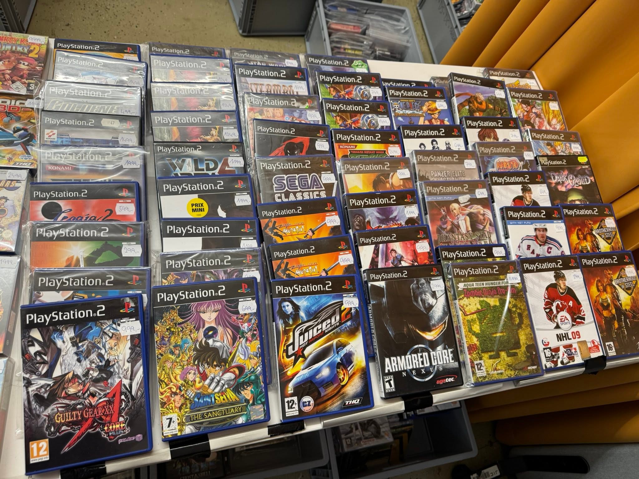Prodejní stůl plný originálních PlayStation 2 her na burze.
